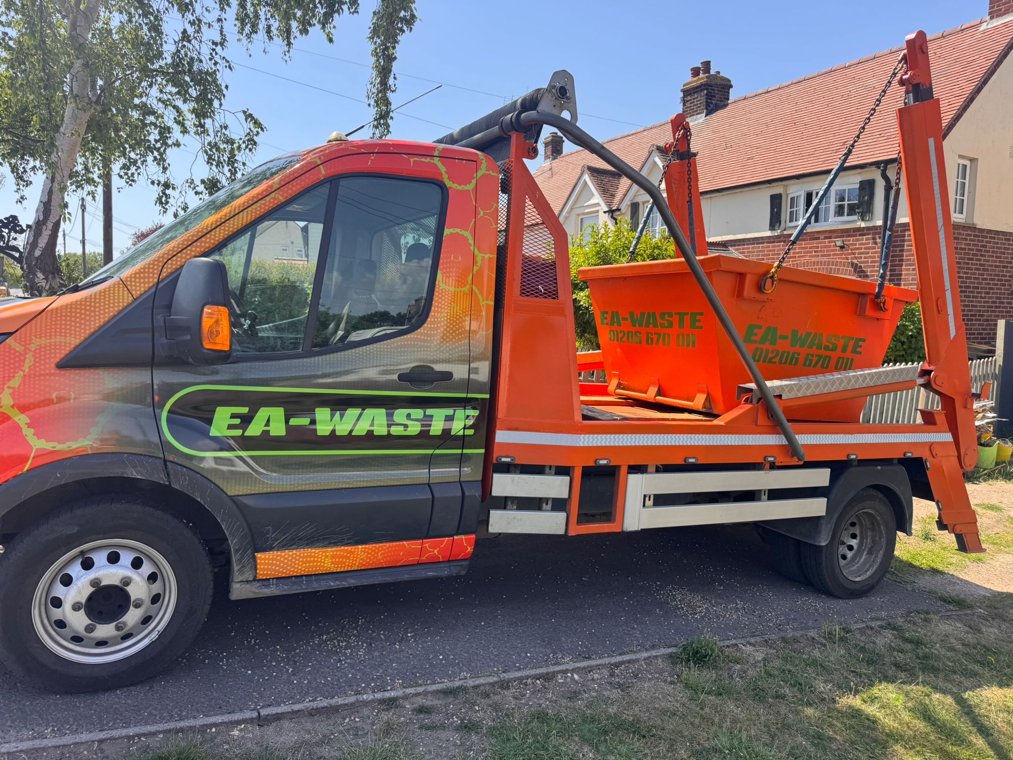 An EA-WASTE commercial skip loader truck carrying a builders skip for trade waste management.