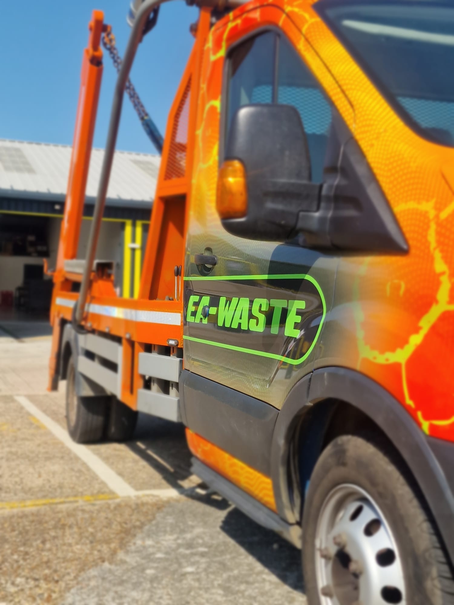 An EA-WASTE commercial skip loader truck carrying a builders skip for trade waste management.